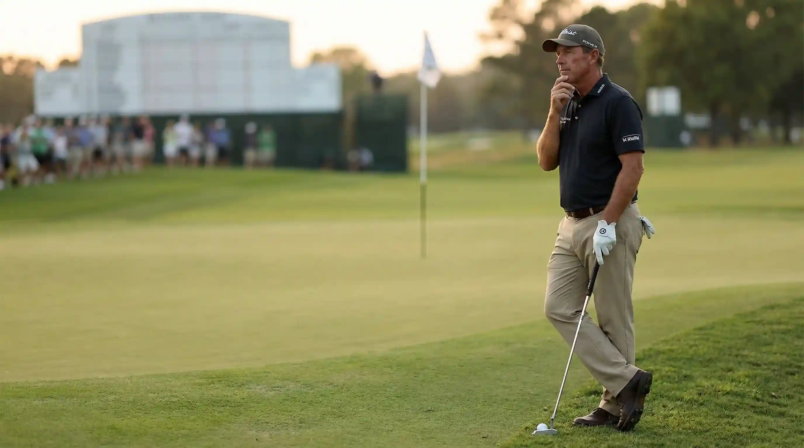 Golfista pensativo junto al green sopesando su siguiente decisión en el torneo